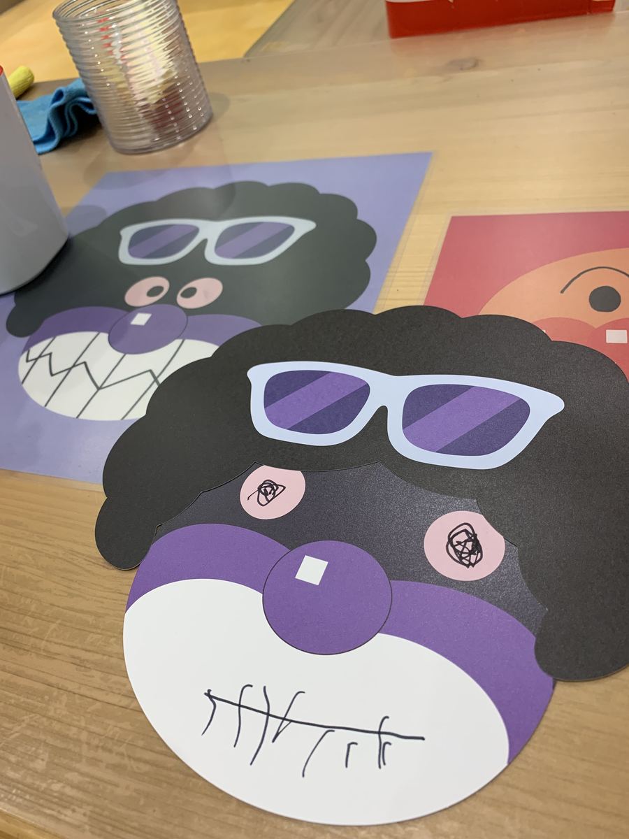 Handmade character masks decorated with marker drawings at the craft station