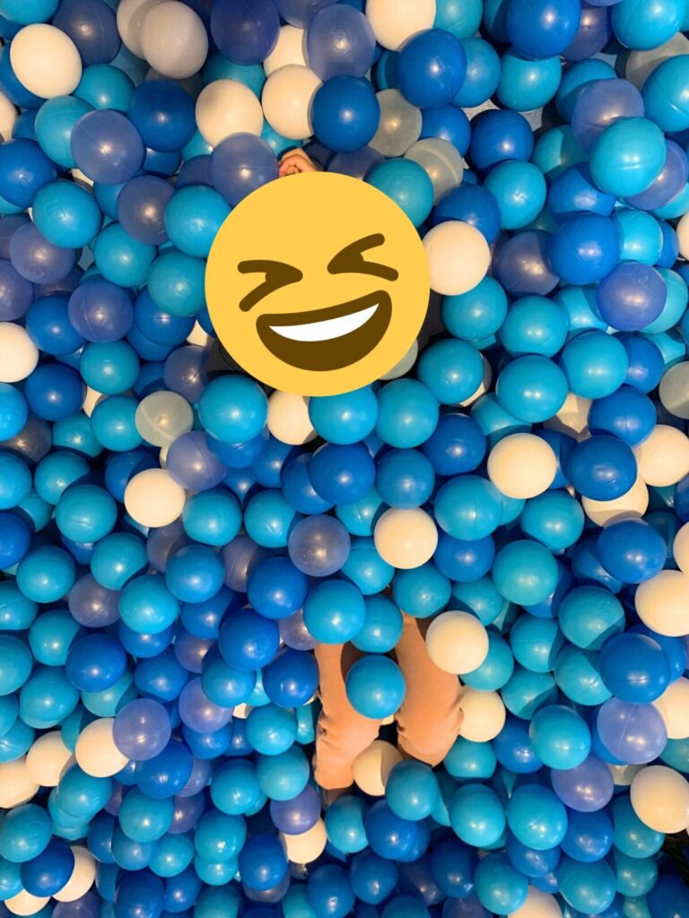 A child enjoying the blue ball-pit area in ASOBono!'s active play zone