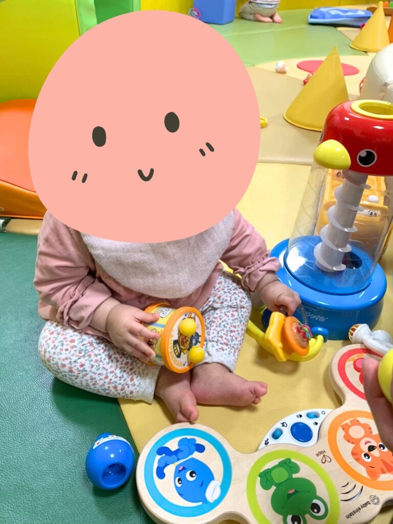 A young child exploring age-appropriate toys in ASOBono!'s baby area