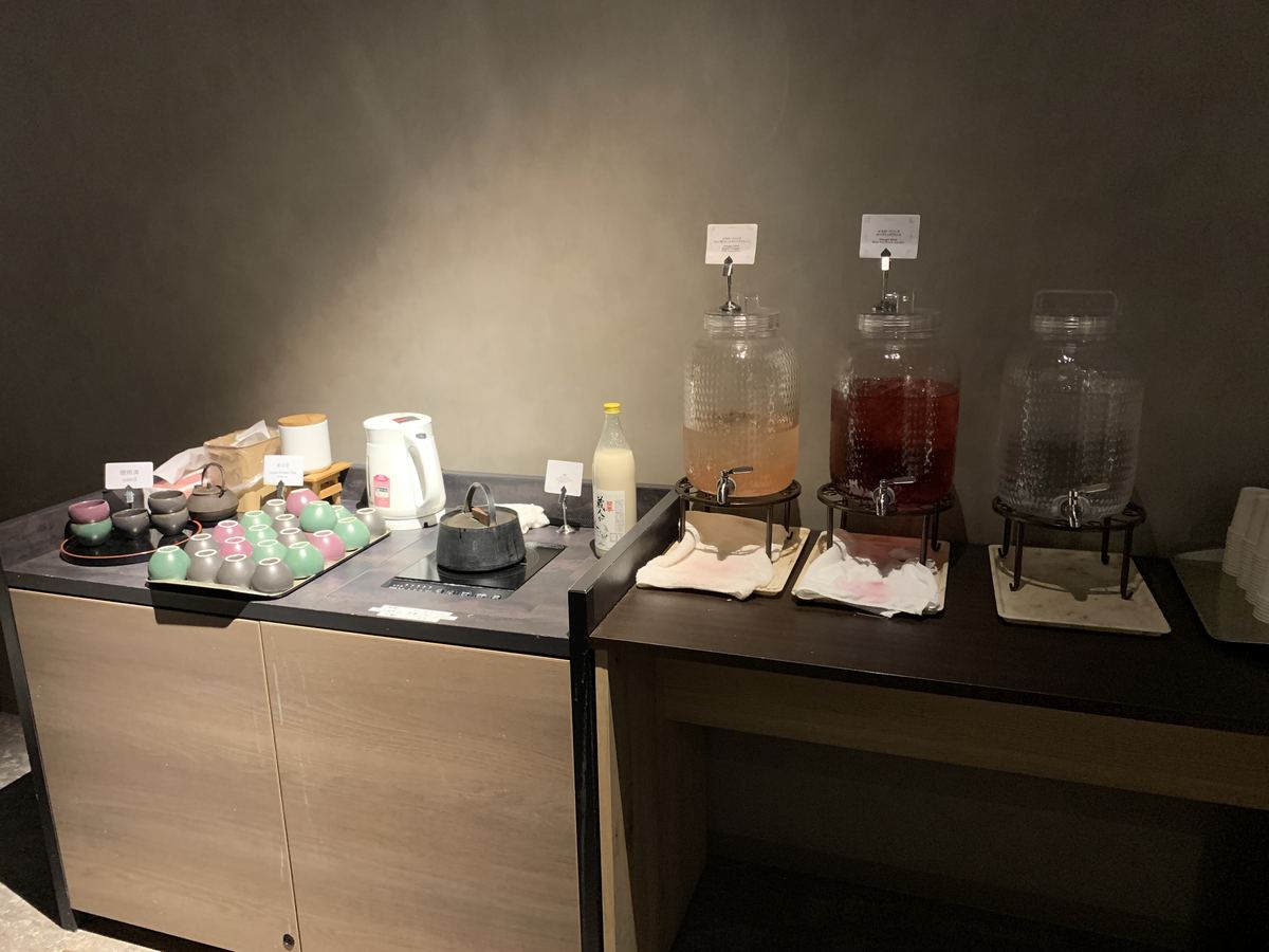 The self-serve lounge drink station at Grand Mercure Nasu Highlands, with amazake, apple-vinegar and rosehip vinegar drinks, local green tea, and a hot-water kettle