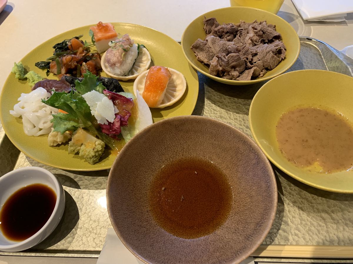 A plate from the dinner buffet at Grand Mercure Nasu Highlands — salmon nigiri, thin-sliced beef, udon, and salad