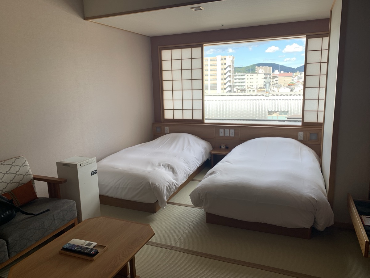 Force family room with beds and a city view at Kyoto Umekoji Kadensho