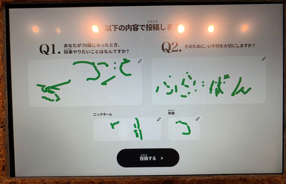 A touch panel showing a child's handwritten answer about life at age 70