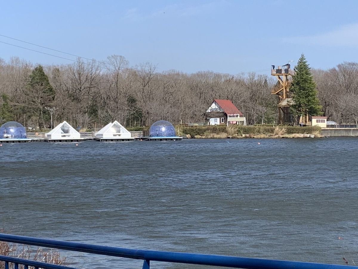 The lake with white glamping domes visible on the far shore