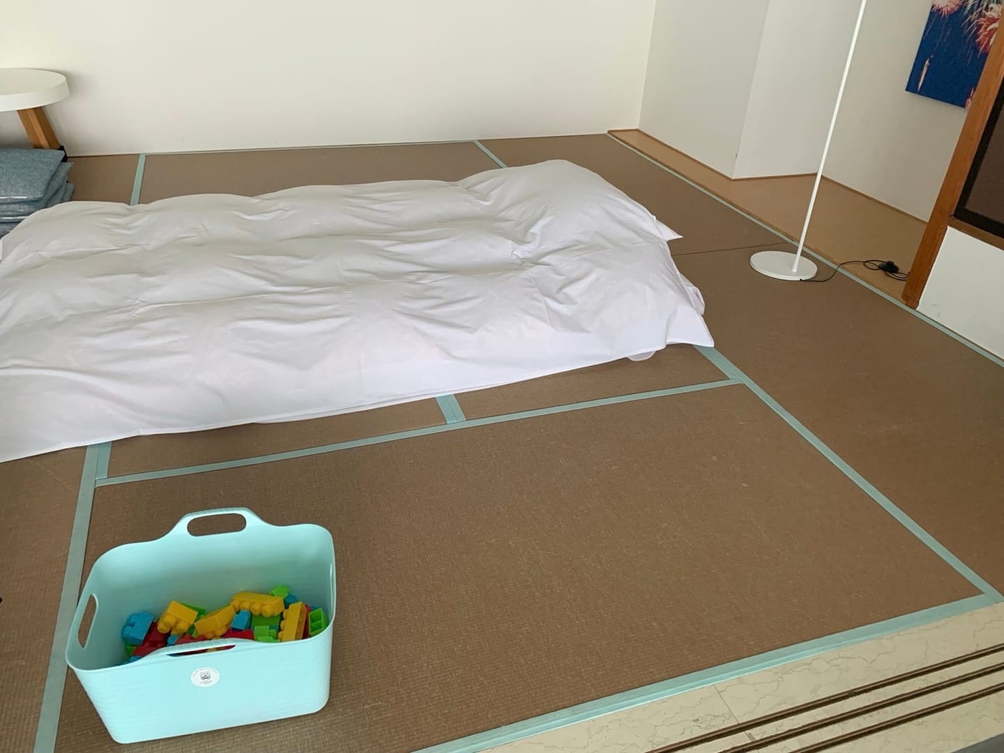 Futon bedding and a basket of building blocks on the room's tatami area