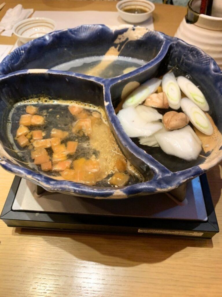 A three-section shabu-shabu pot with different broths