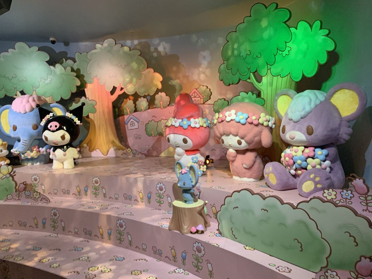 A pastel forest scene with My Melody, Kuromi, and friends inside the dark ride