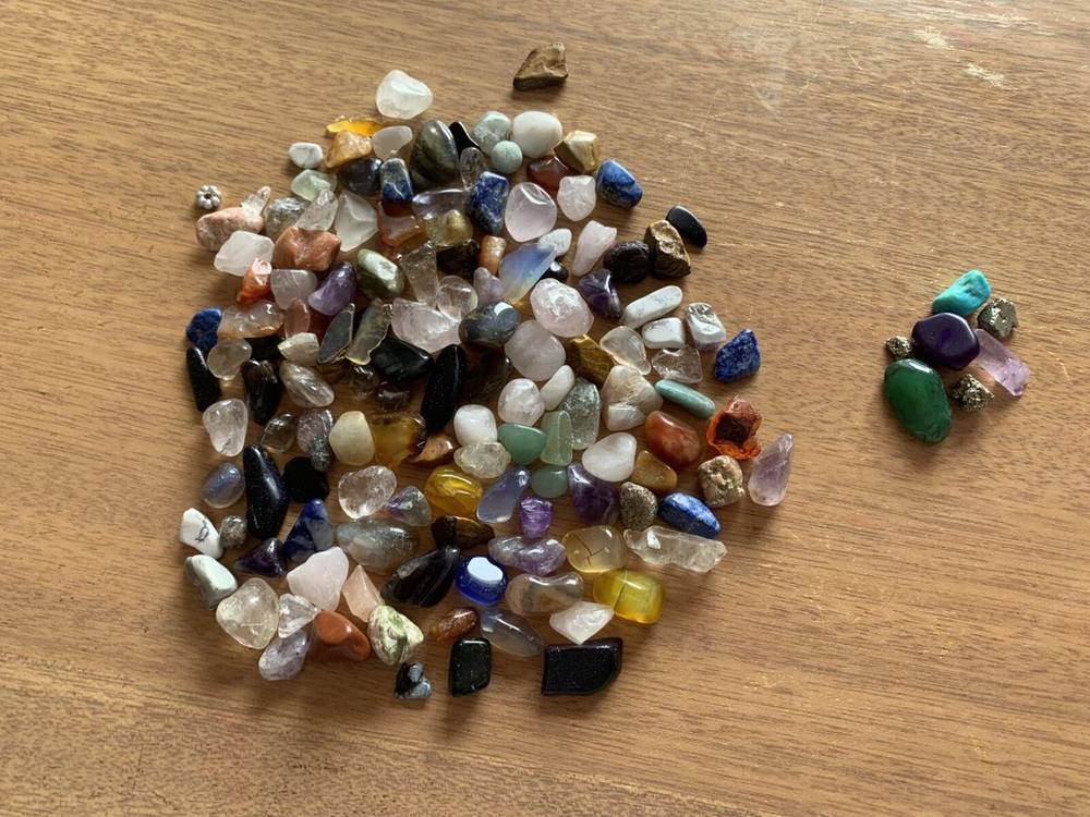 The full family gem haul spread out — amethyst, quartz, and dozens of small polished stones
